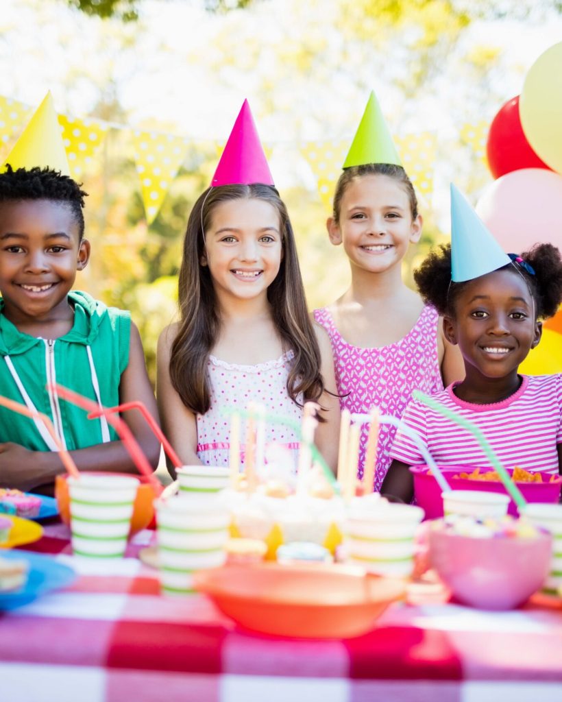 Group of children smiling and posing during a birthday party on a park